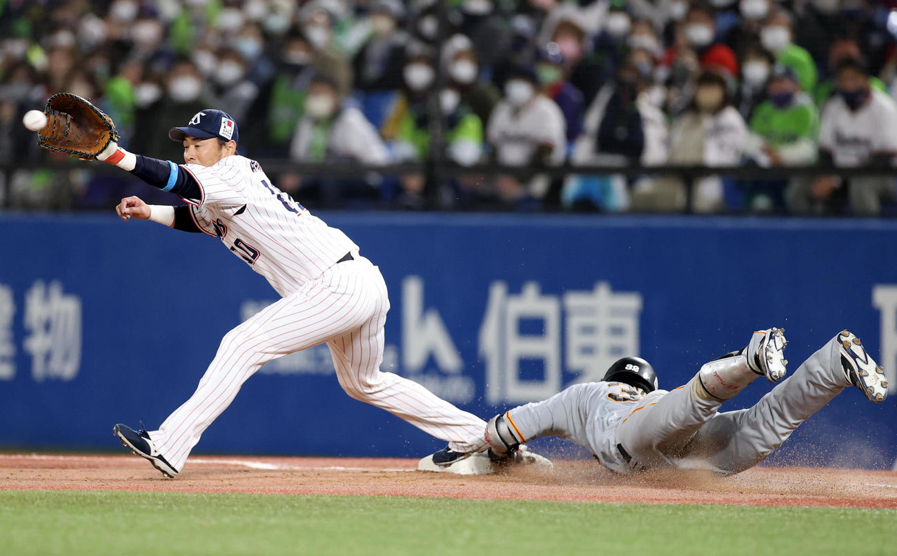ヤクルト対巨人　8回表巨人2死二、三塁、適時内野安打を放ち、一塁へ滑り込む広岡（右）。左は荒木（撮影・狩俣裕三）