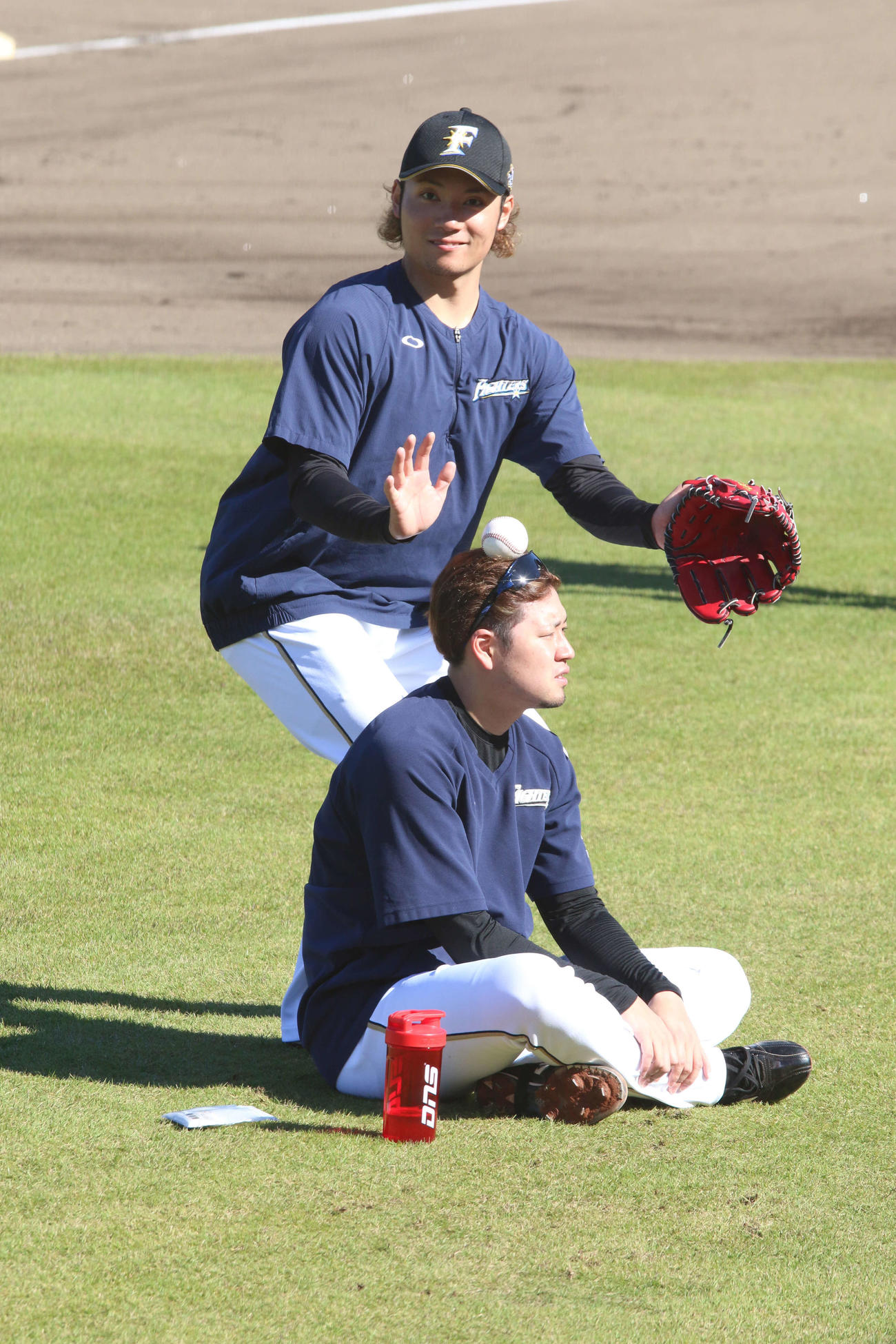 堀の頭上にボールを乗せてポーズを決める日本ハム伊藤（撮影・田中彩友美）