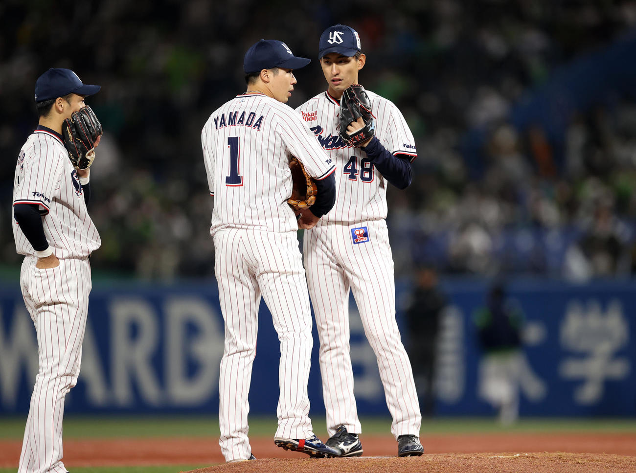 クルト対巨人　2回表途中、先発原の負傷交代により、緊急登板する金久保（右）に声をかける山田（中央）（撮影・狩俣裕三）