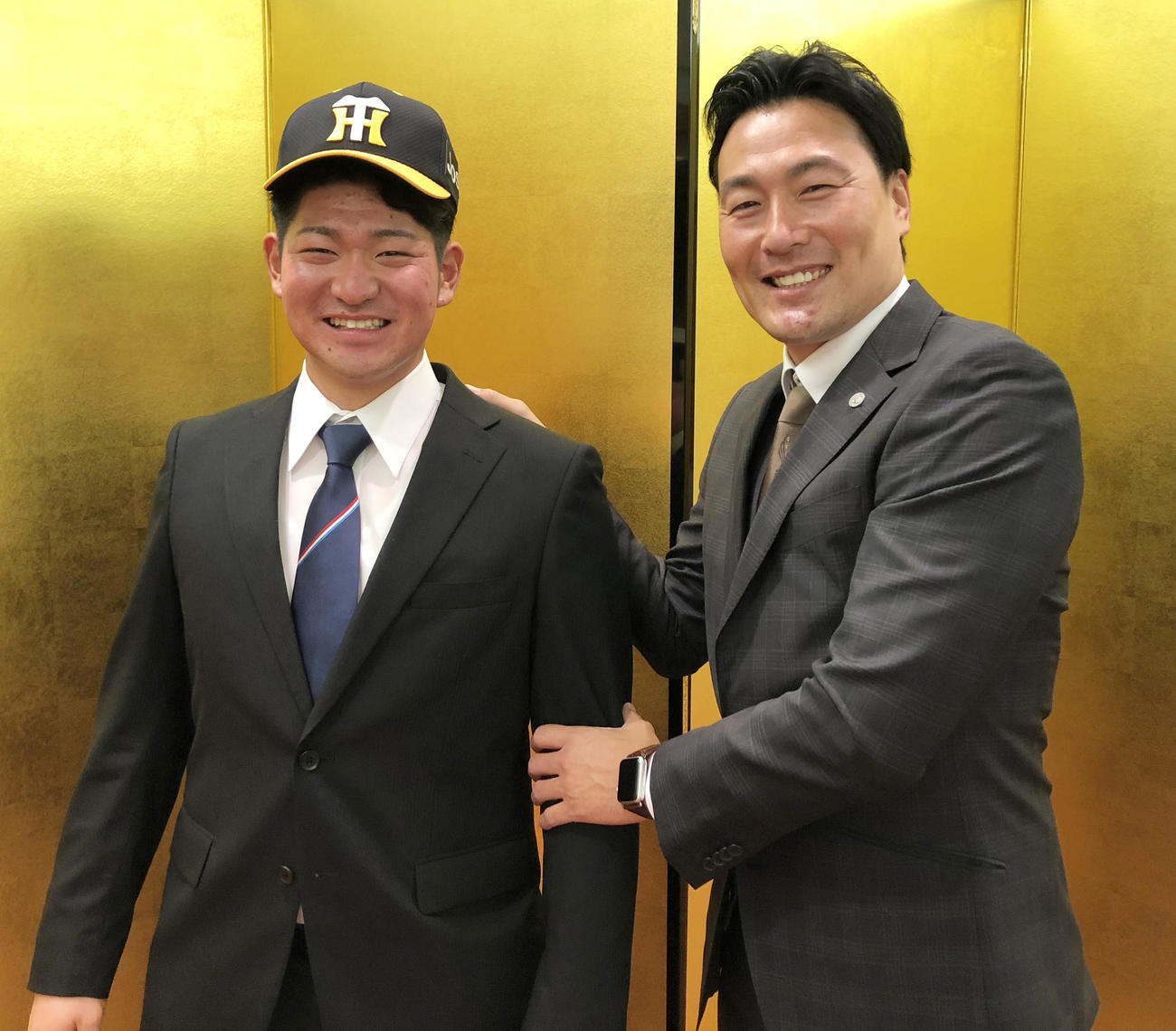 仮契約を結び笑顔をみせる阪神育成ドラフト1位の伊藤稜（左）、右は筒井スカウト（阪神球団提供）