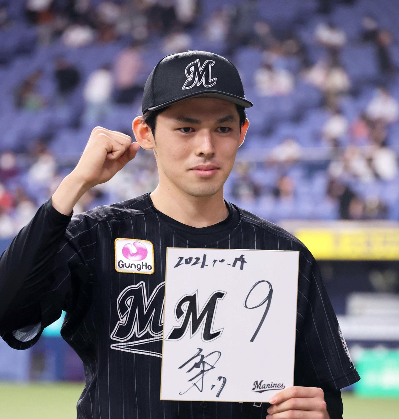 10月14日、6回無失点の好投でM9を点灯させた佐々木朗希は色紙を手にガッツポーズ