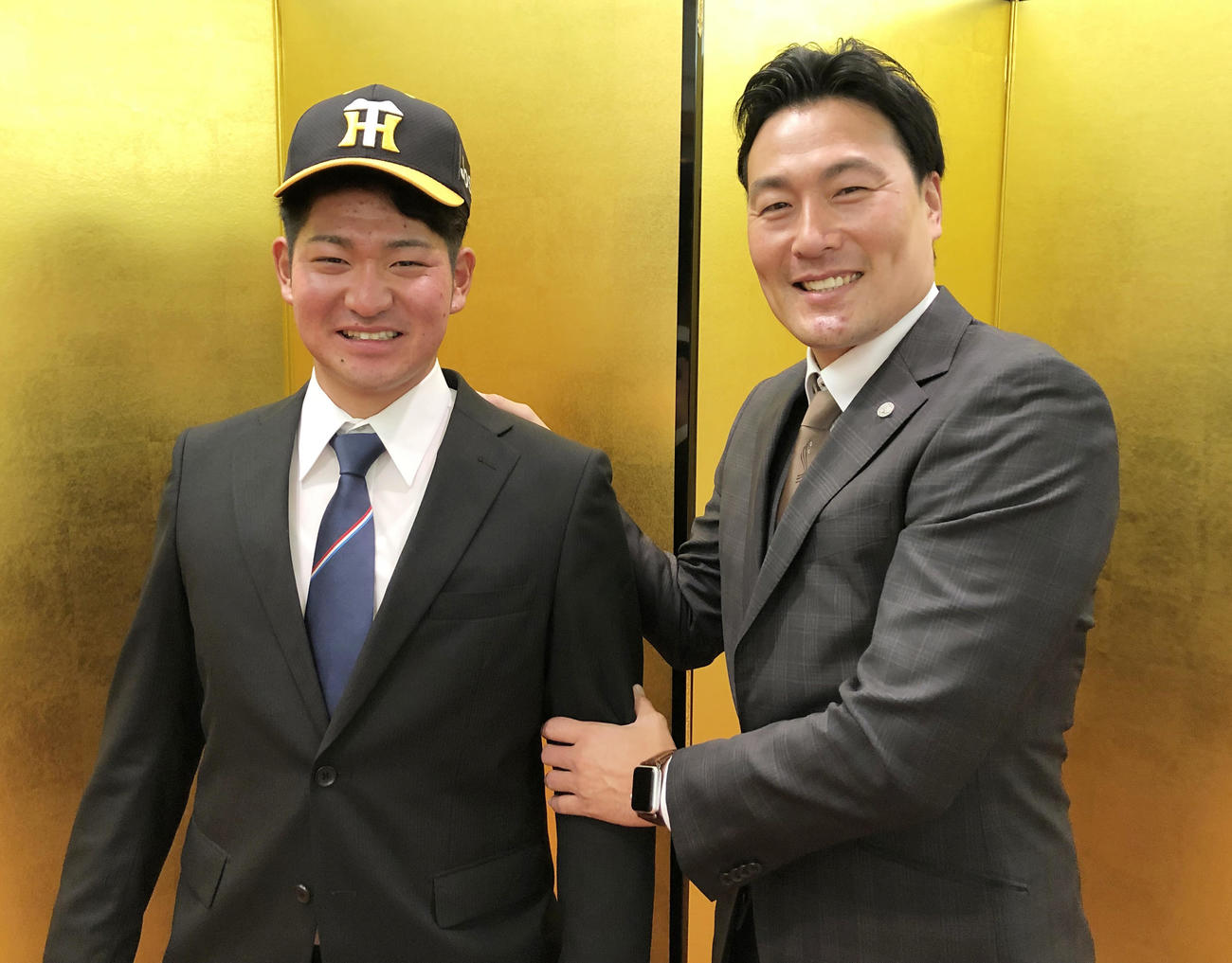 仮契約を結び笑顔をみせる阪神育成ドラフト1位の伊藤稜（左）、右は筒井スカウト（阪神球団提供）