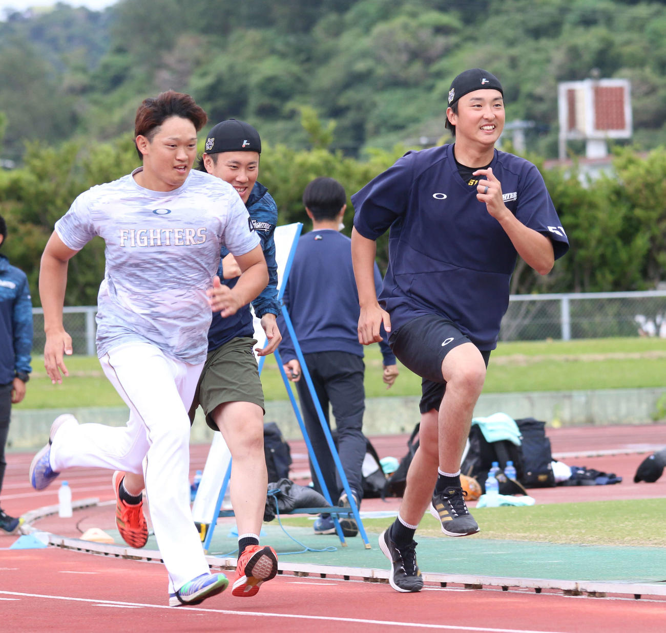 日本ハム石川直（右）は笑顔で走り込む（撮影・田中彩友美）