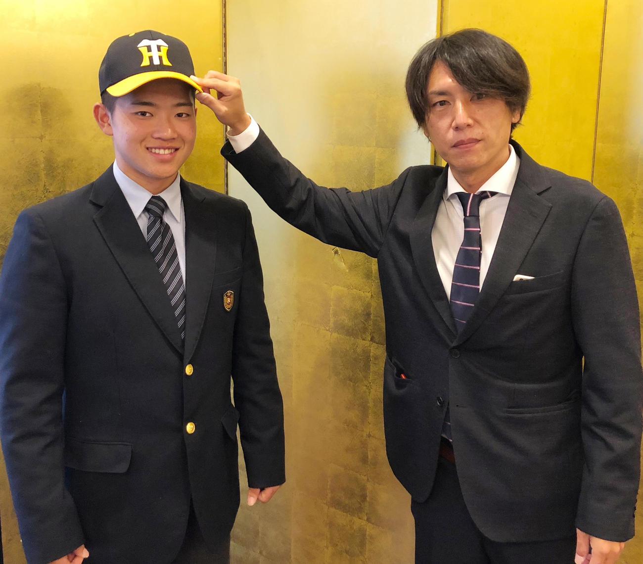 仮契約を結び笑顔をみせる阪神ドラフト7位の中川、右は渡辺スカウト（球団提供）
