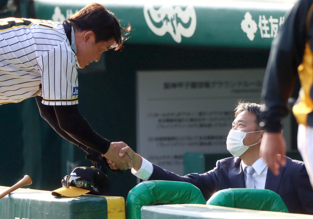 ベンチに現れた野村氏（右）と握手を交わす新井打撃コーチ（撮影・上山淳一）