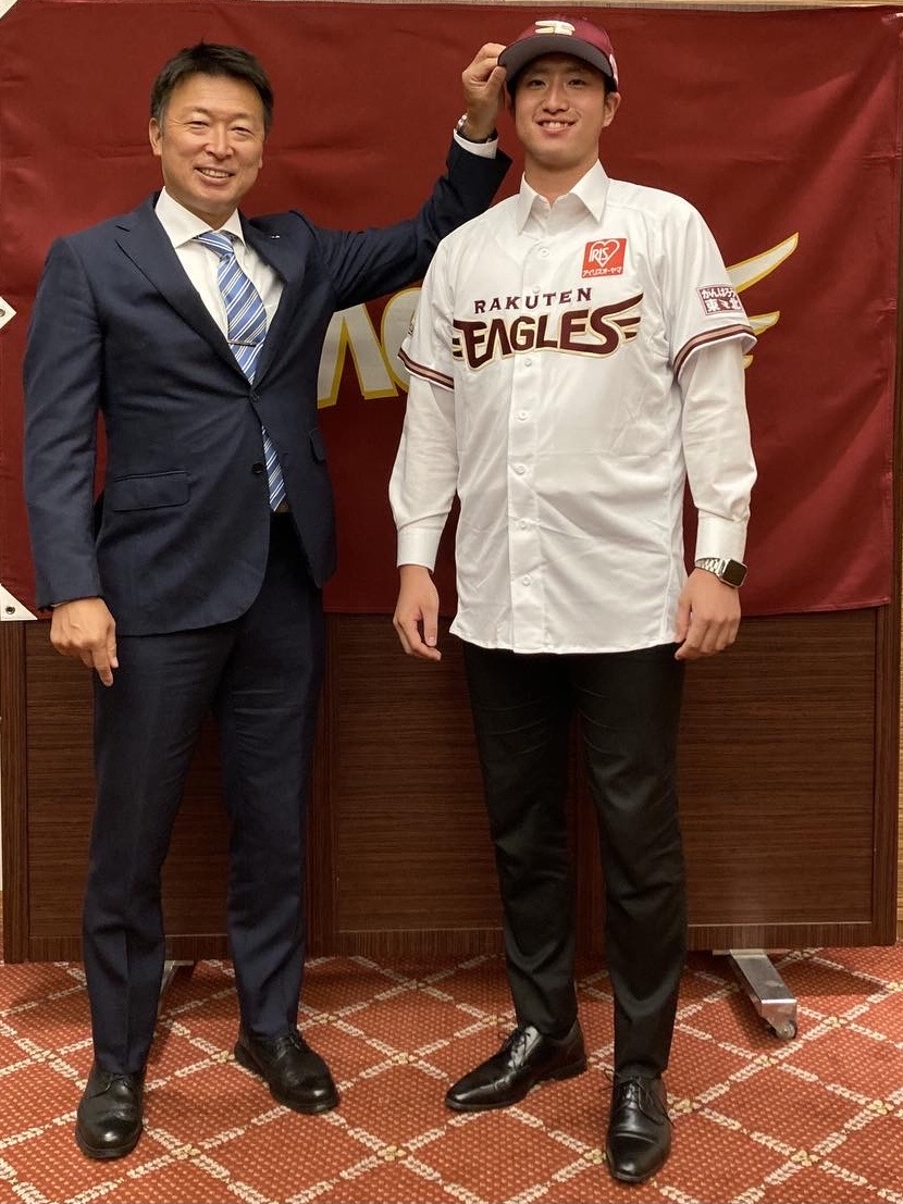 契約合意した楽天ドラフト6位の早大・西垣（右）は沖原スカウトから帽子をかぶせてもらう（球団提供）
