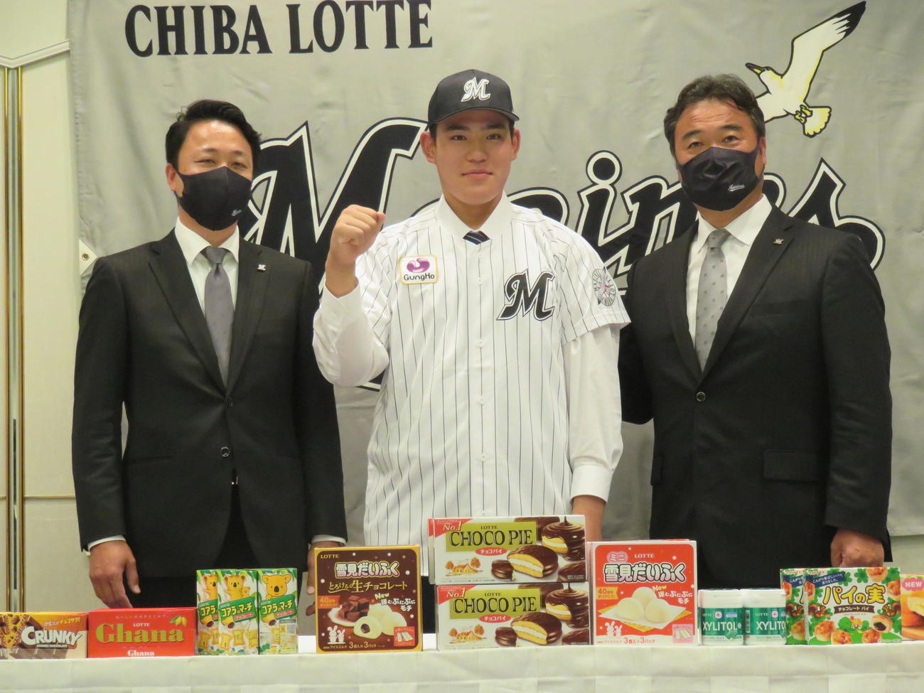 ロッテ育成ドラフト4位、幕張総合・村山亮介捕手（中央）は契約してガッツポーズ。左は小林担当スカウト、右は永野スカウト部長