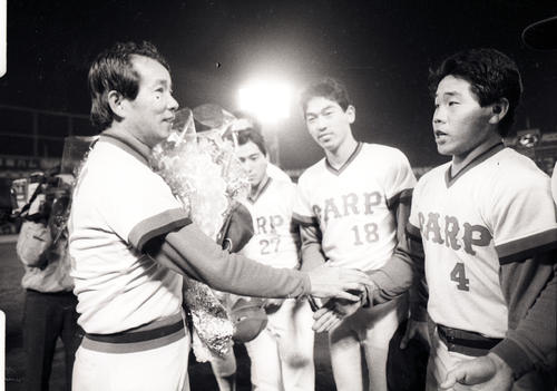1985年、地元での最終戦を終え、花束を手にナインと握手する広島監督の古葉竹識さん（左端）