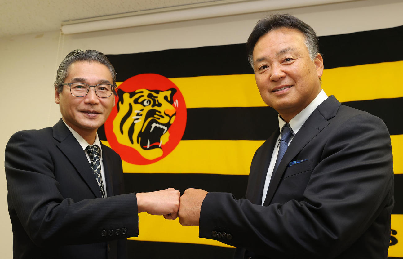 就任会見を終え、阪神嶌村球団本部長（左）とグータッチを交わす藤井1・2軍巡回打撃コーチ（撮影・前田充）