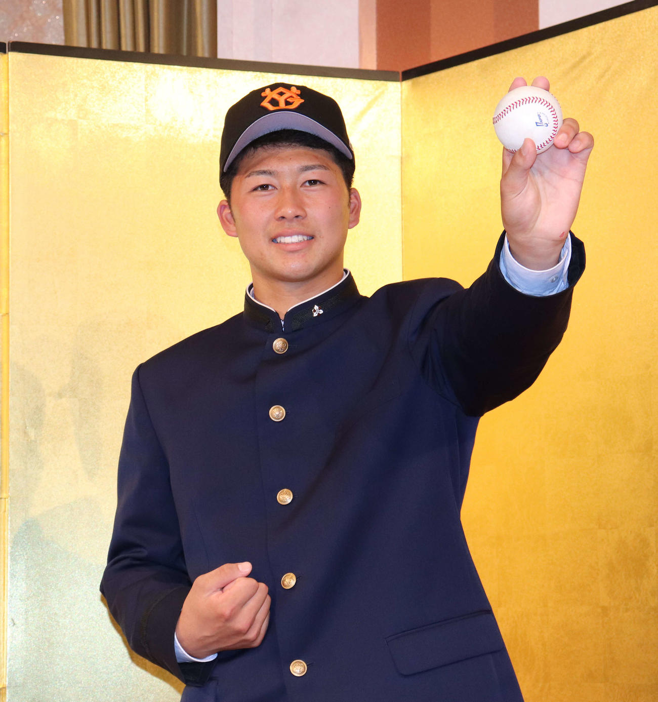 仮契約を結び記者会見に出席した巨人ドラフト6位の明徳義塾・代木は投球するポーズを見せる（撮影・小早川宗一郎）
