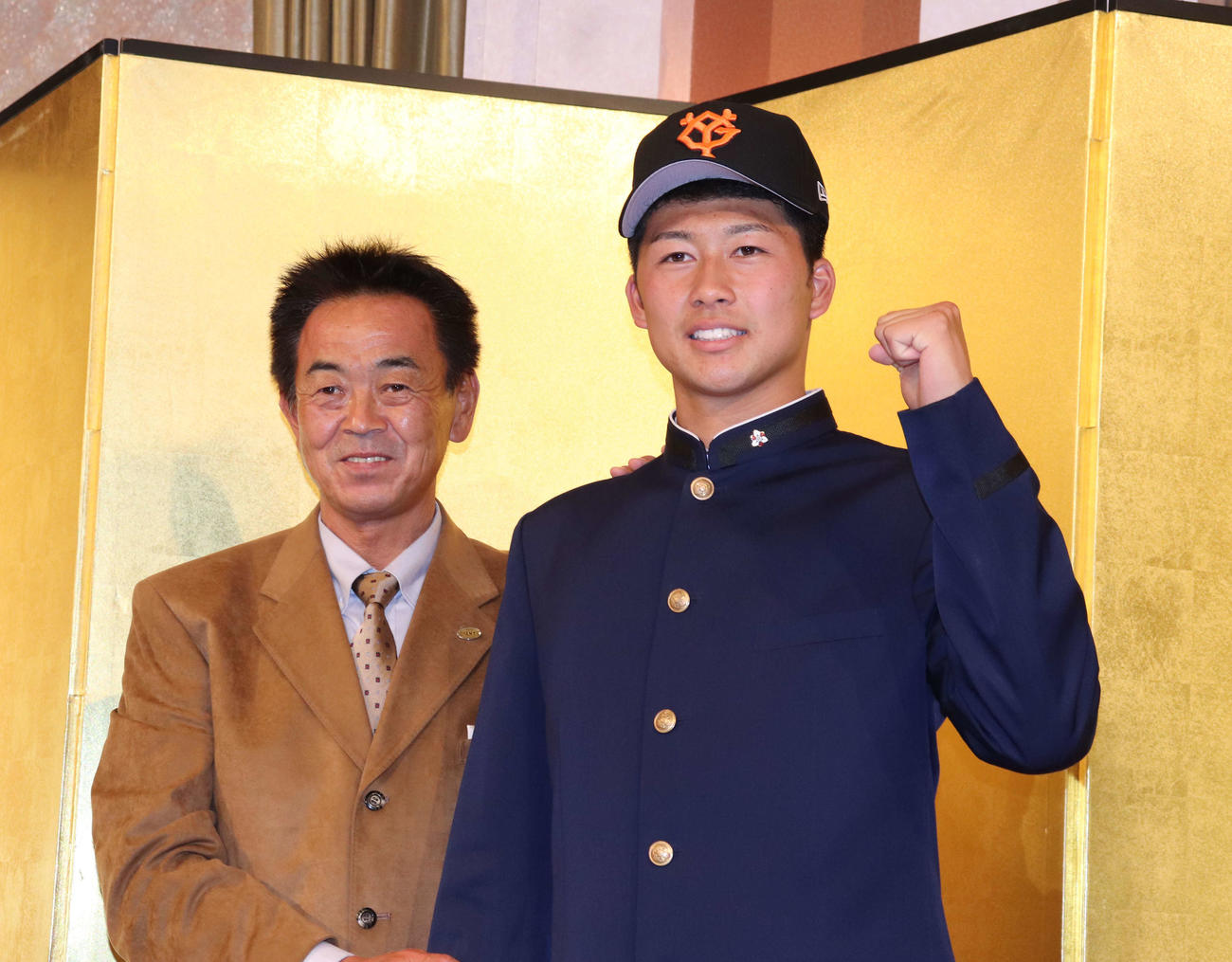 仮契約を結び笑顔を見せる巨人ドラフト6位の明徳義塾・代木（右）と水野スカウト部長（撮影・小早川宗一郎）