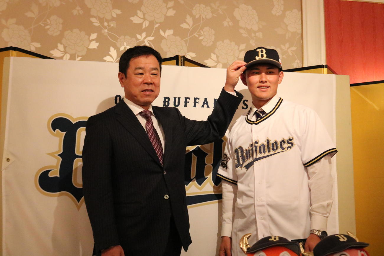 オリックスとの仮契約を済ませた関大・野口智哉は、福良GMに帽子をかぶせてもらう（撮影・林亮佑）