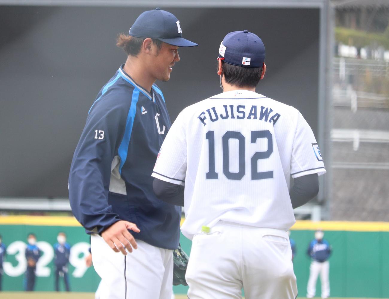 キャッチボール相手の藤沢亨明ブルペン捕手と笑顔で話す西武・高橋光成投手（撮影・阿部泰斉）