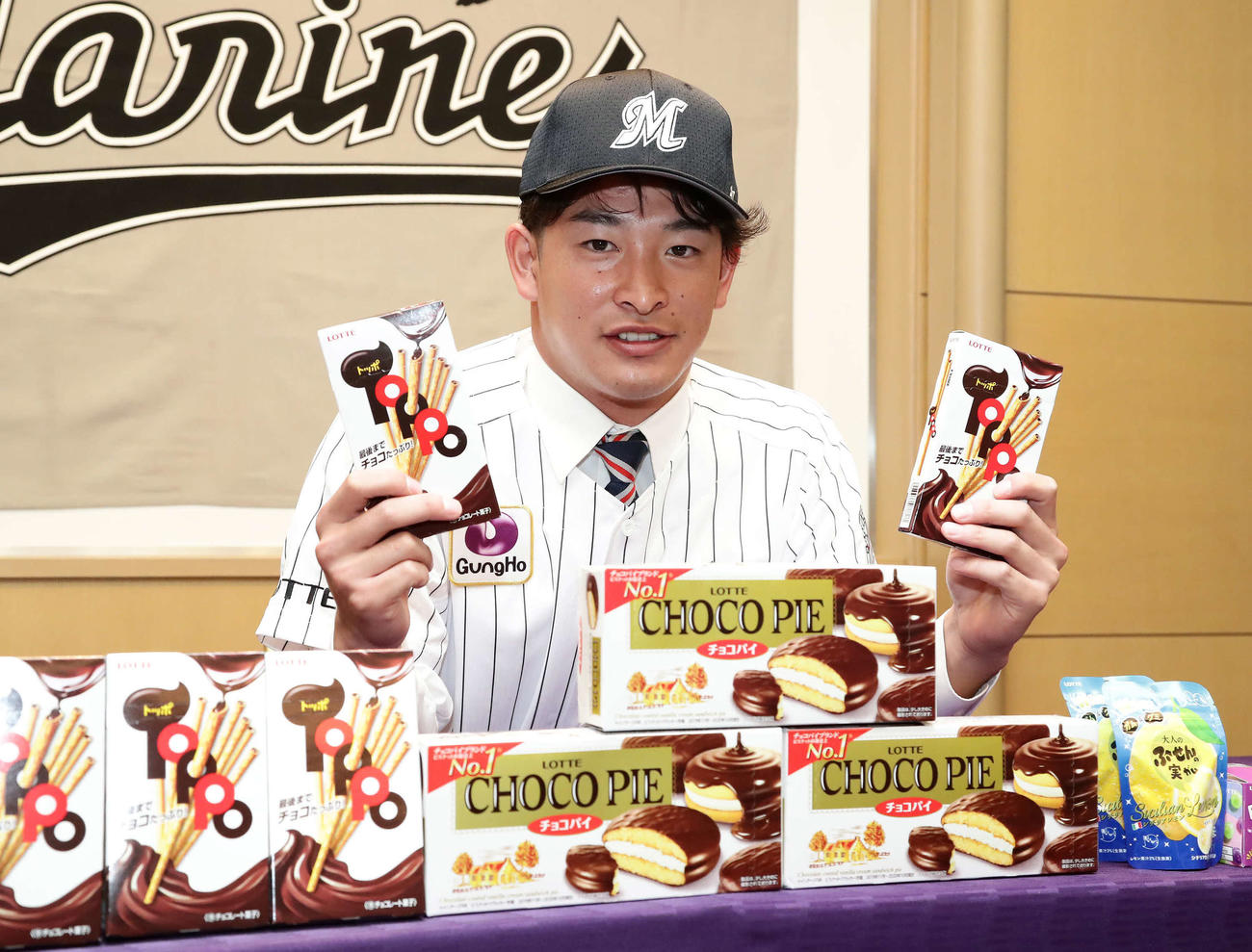 ロッテと仮契約を結びお菓子を手に写真に納まる池田（撮影・丹羽敏通）
