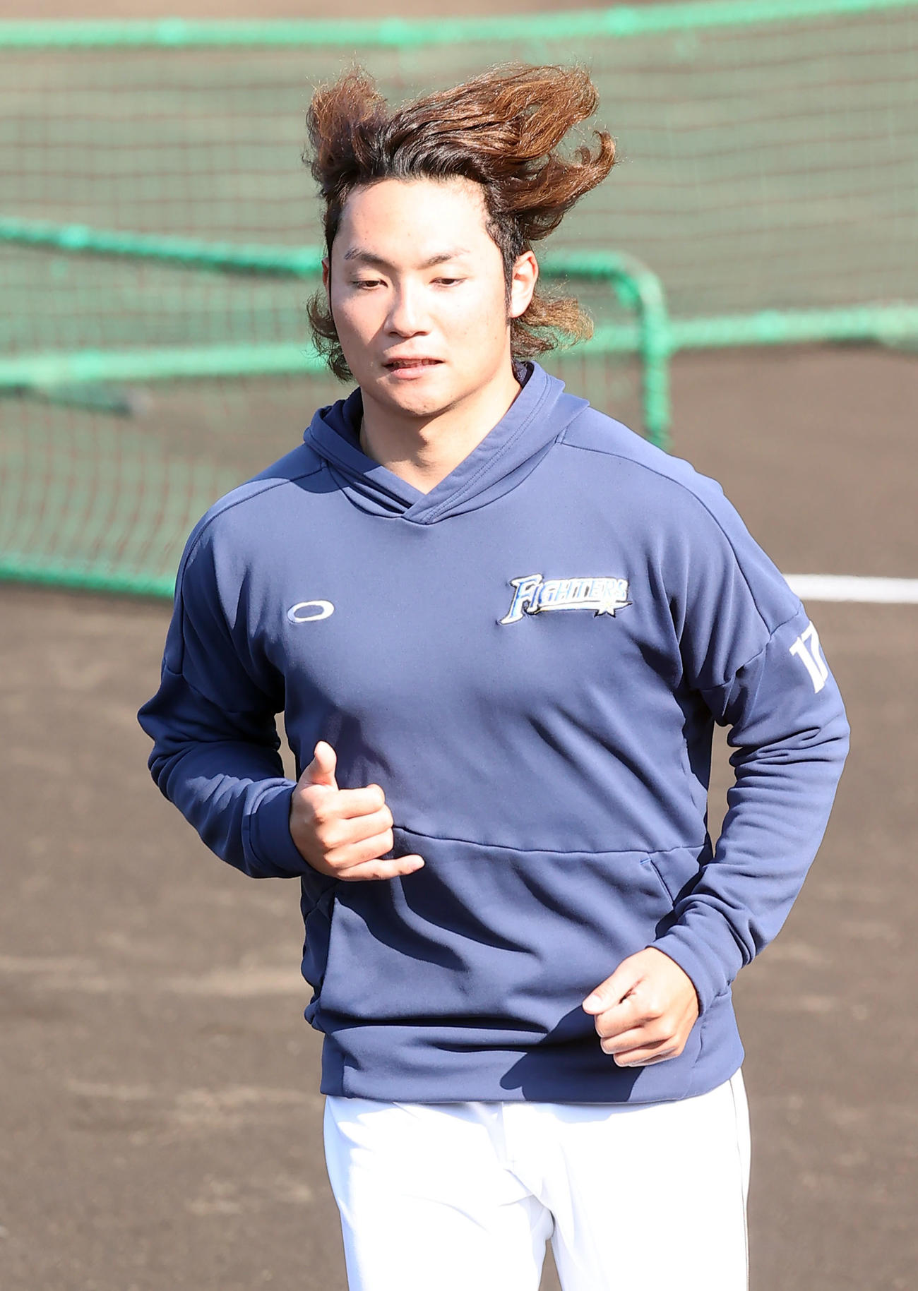 練習を視察に訪れた日本ハム新庄監督にあいさつし駆け足で練習に戻る伊藤の右手はビッグボスポーズ（撮影・垰建太）