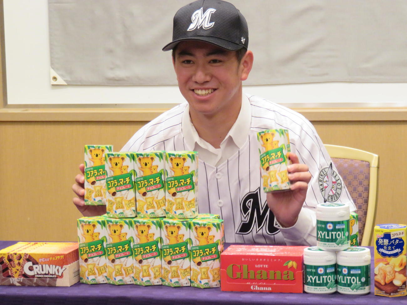 ロッテのドラフト4位、二松学舎大付・秋山は契約を終え、好物のコアラのマーチを手に笑顔