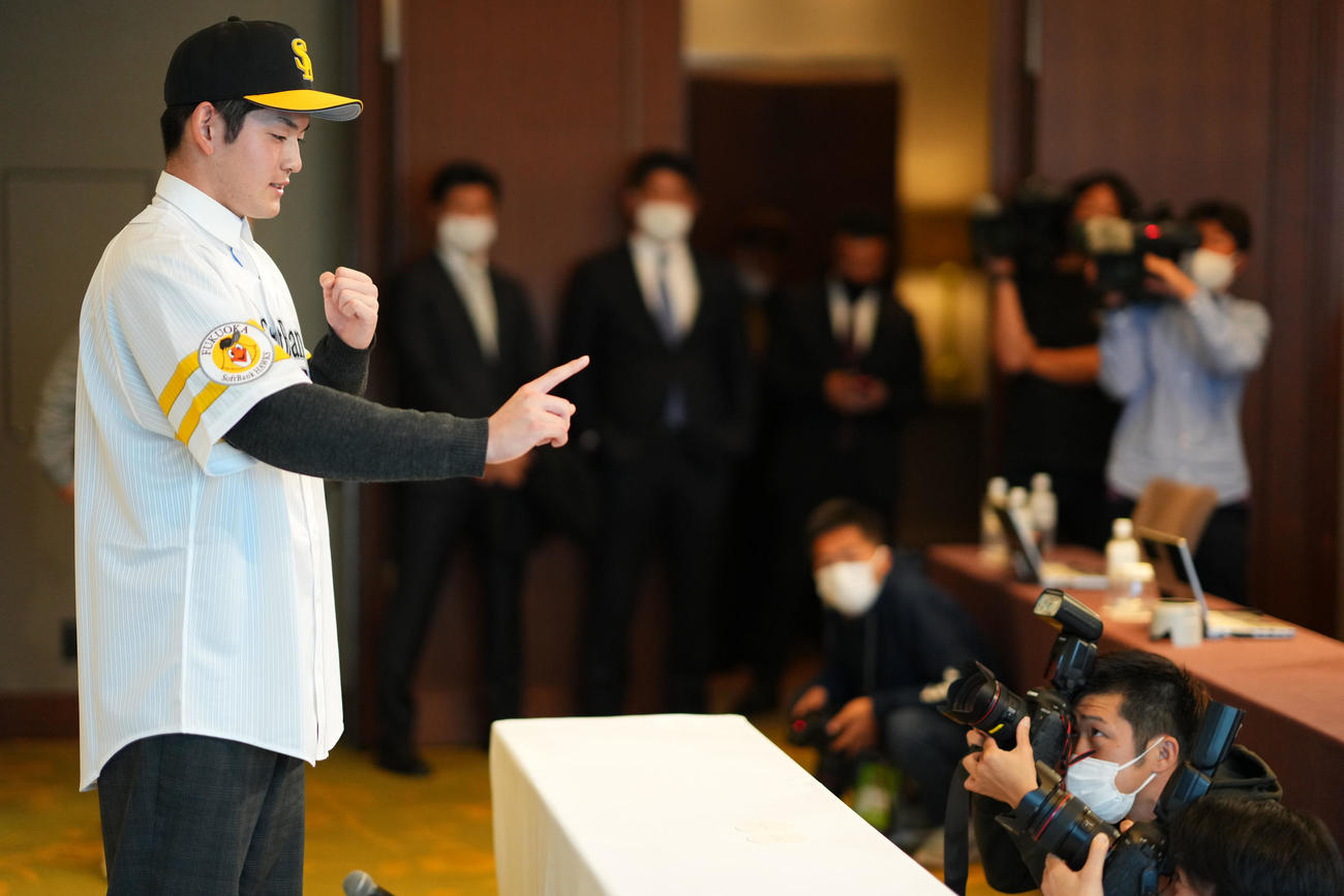 仮契約を終えたソフトバンクドラフト1位のノースアジア大明桜・風間は1本指を立て笑顔を見せる（撮影・横山健太）