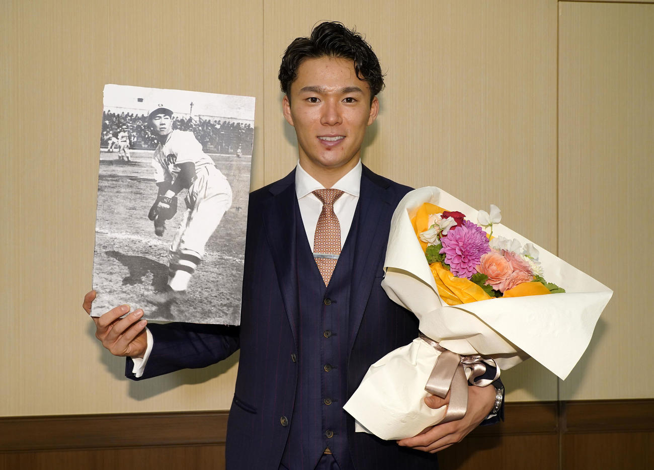 沢村賞を受賞し沢村栄治投手の写真と花束を手に笑顔を見せるオリックス山本由伸
