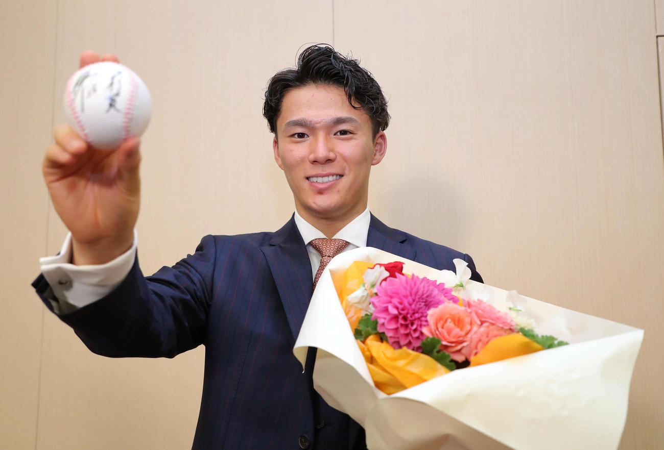 ボールに沢村賞と記して、花束を手に笑顔を見せるオリックス山本