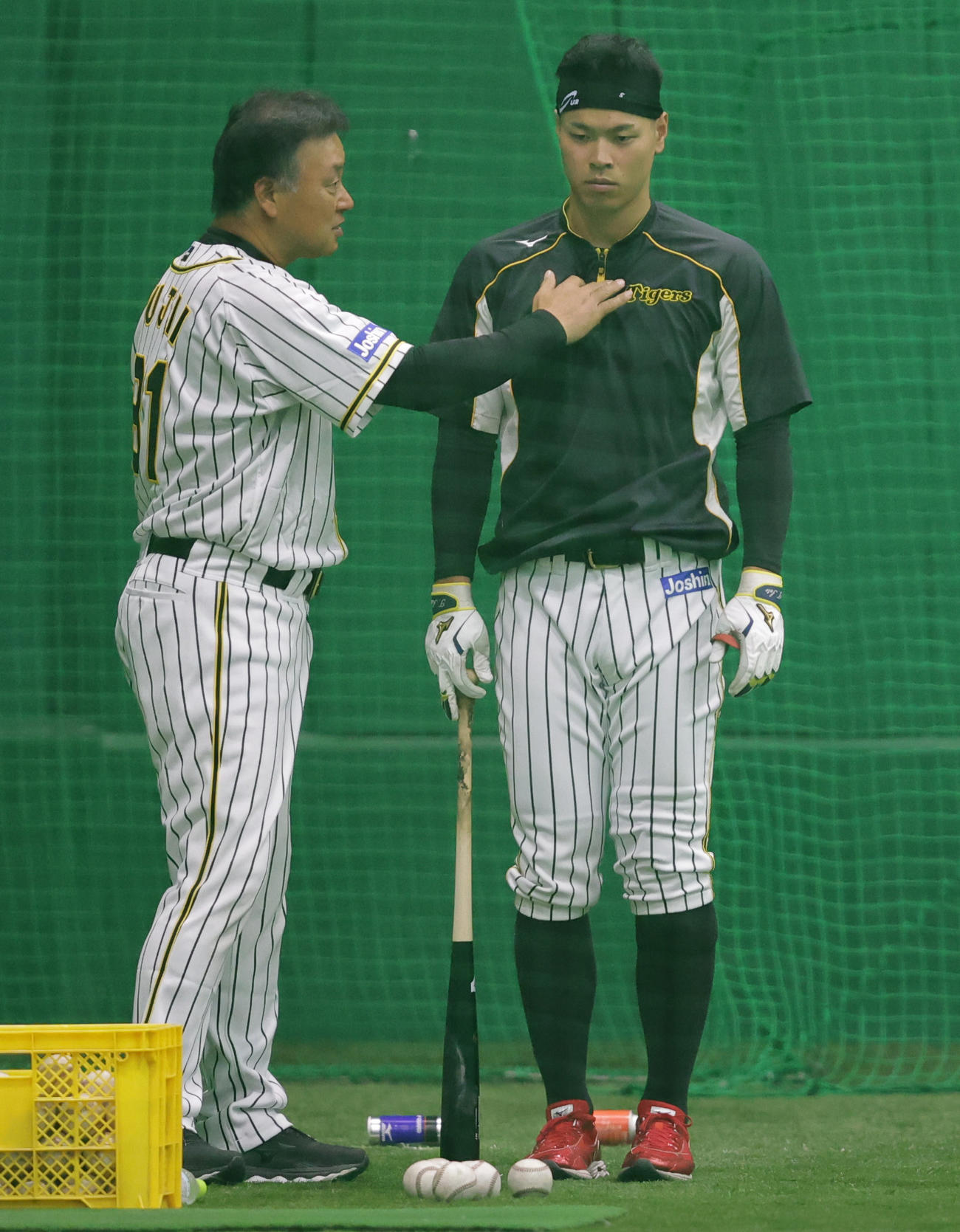 阪神藤井康コーチ（左）から指導を受ける佐藤輝（撮影・清水貴仁）