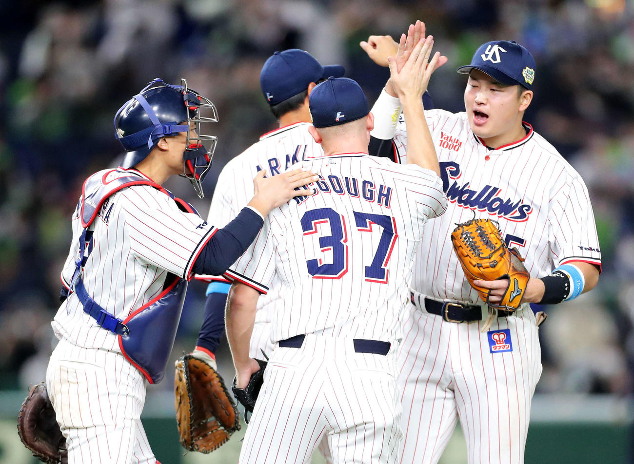 ヤクルト対オリックス　オリックスに勝利し、中村（左）村上（右）らナインに迎えられるマクガフ（撮影・河田真司）