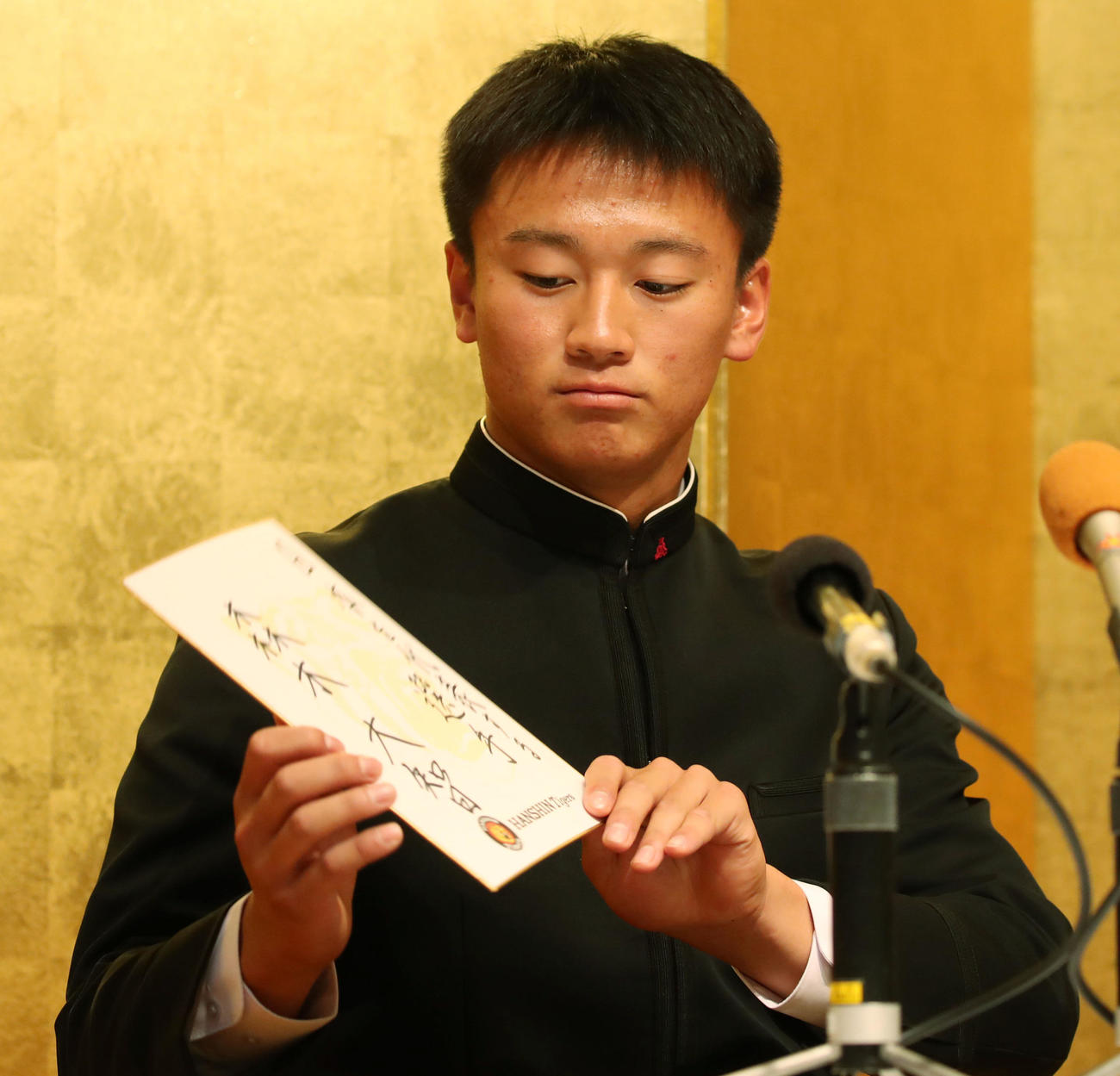 仮契約を終え会見する阪神ドラフト1位指名の森木は色紙を手にする（撮影・加藤哉）
