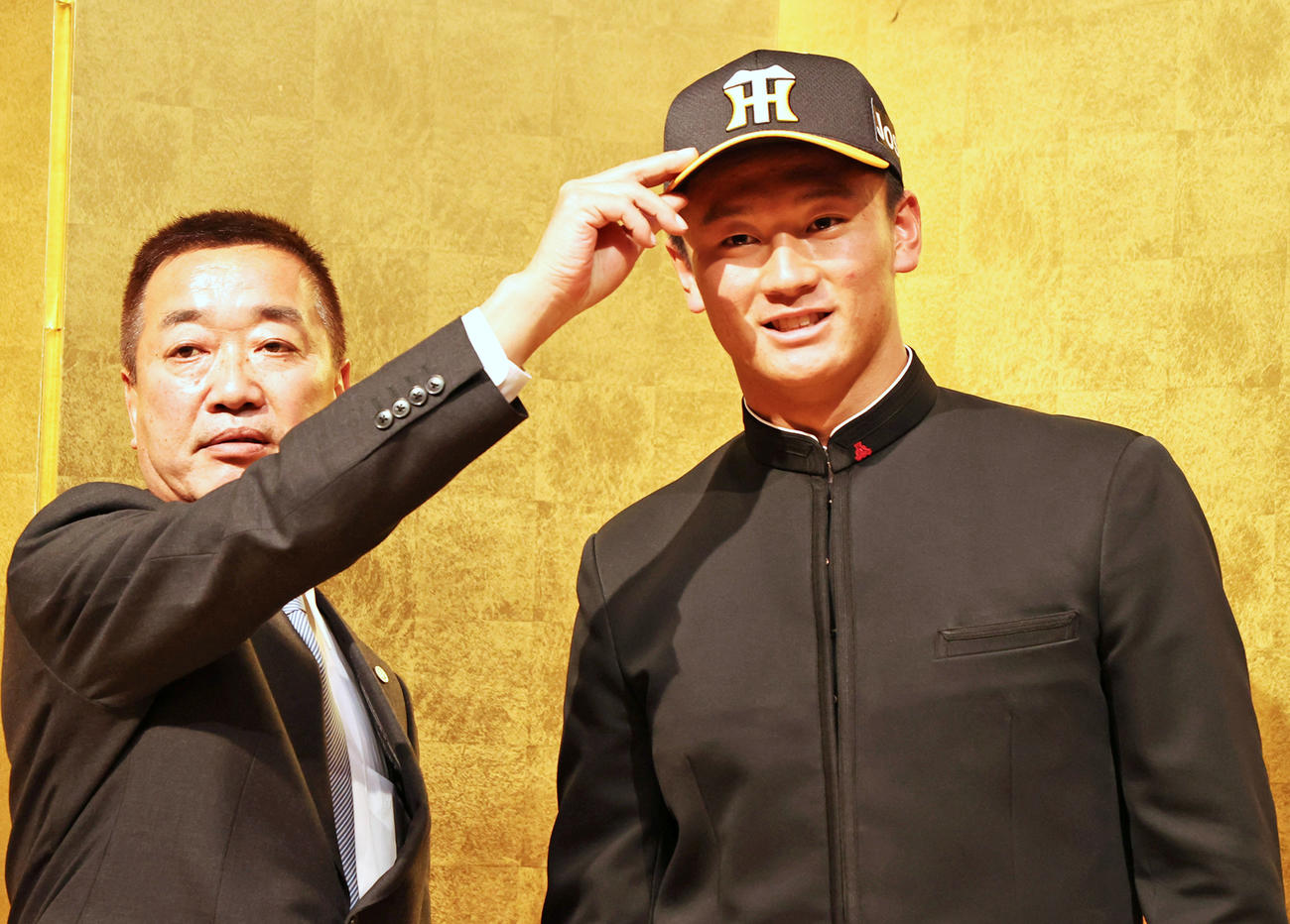 仮契約を終え山本スカウト（左）から帽子をかぶせてもらう阪神ドラフト1位指名の森木（撮影・加藤哉）