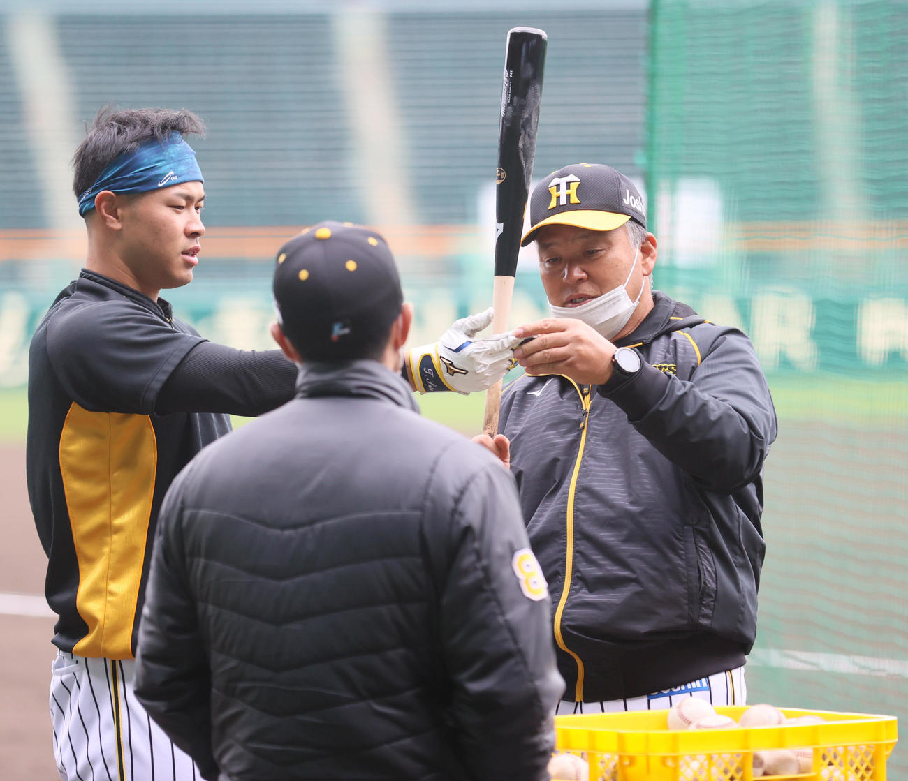 佐藤輝（左）を指導する藤井康巡回打撃コーチ（撮影・上山淳一）