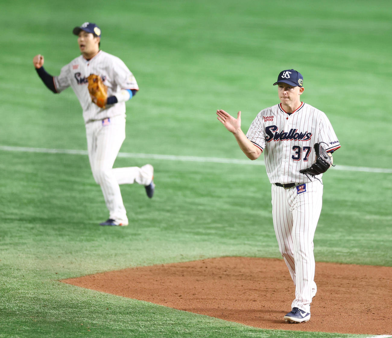 ヤクルト対オリックス　セーブを挙げたヤクルト・マクガフ（右）は力強くグラブをたたく。二塁手山田（撮影・垰建太）