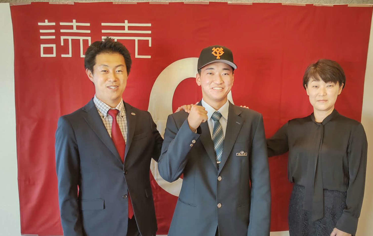 仮契約を結びガッツポーズを見せる巨人育成ドラフト4位の上田西・笹原（中）と母まゆみさん（右）、担当の円谷スカウト（左）（球団提供）