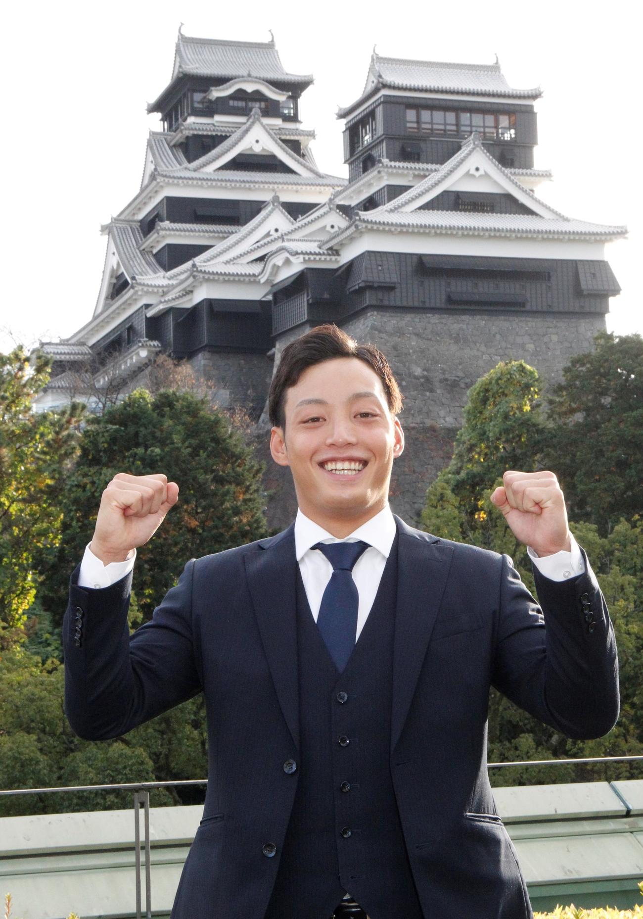 仮契約を終え、熊本城をバックに気合を込める中日3位指名の火の国サラマンダーズ石森大誠投手（撮影・菊川光一）