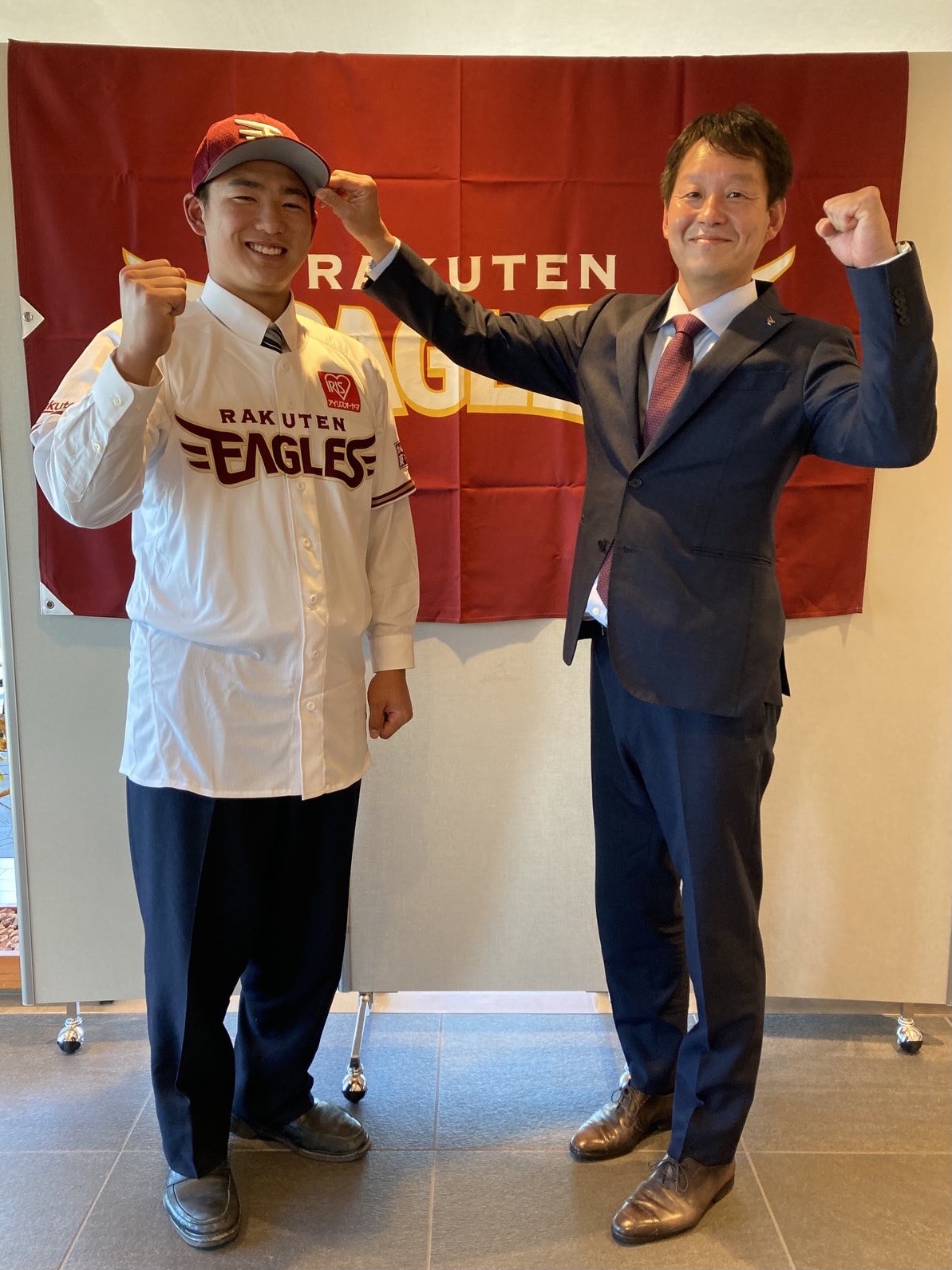 楽天ドラフト3位の三島南・前田（左）は契約合意し、部坂スカウトから帽子をかぶせてもらいガッツポーズ（楽天野球団提供）
