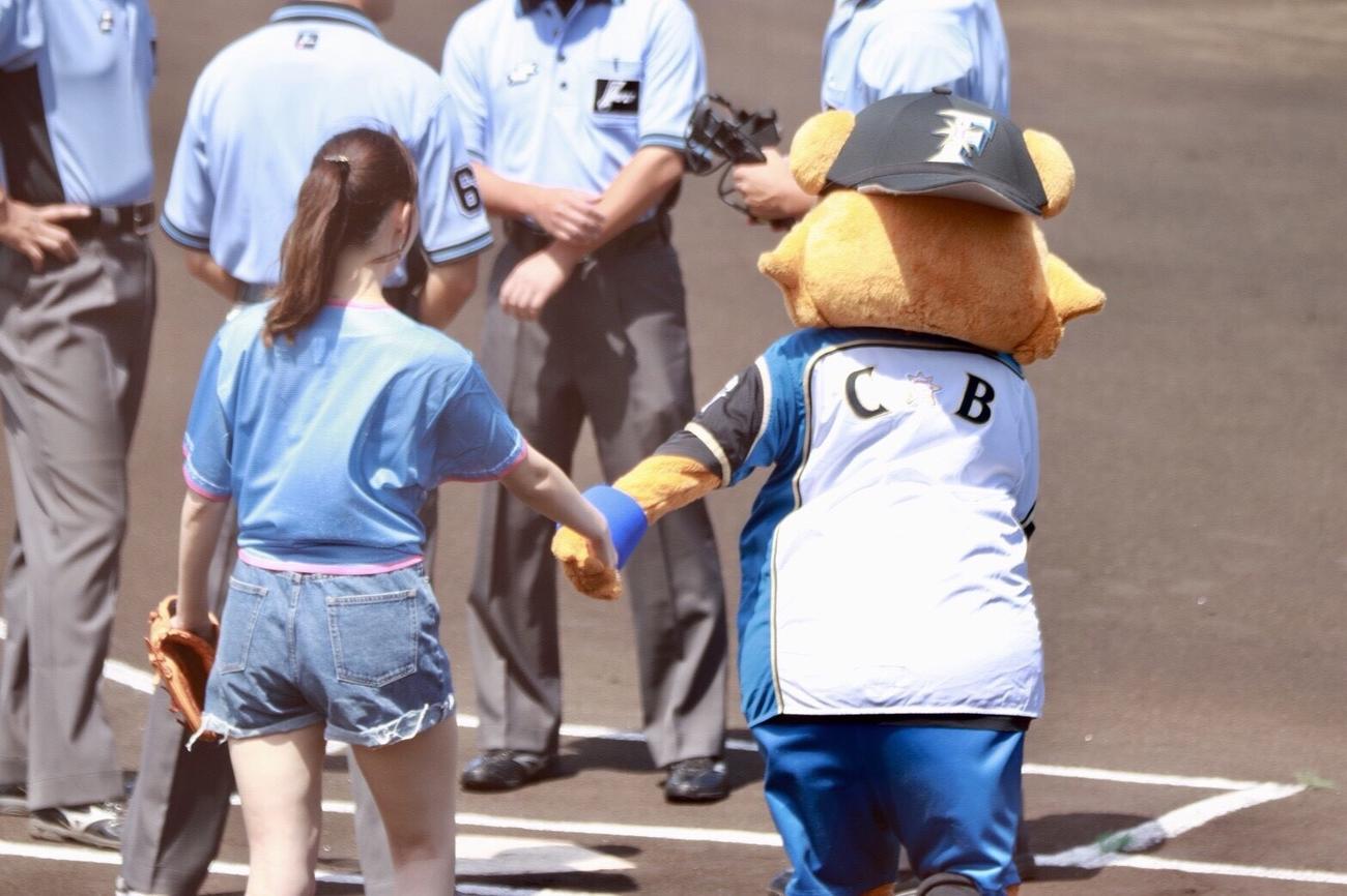 カビーに手をひかれ始球式へ向かう藤江れいな