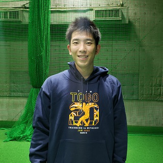自身がデザインに携わった「TEAM TOGO」パーカを着用し笑顔を見せる巨人戸郷（球団提供）