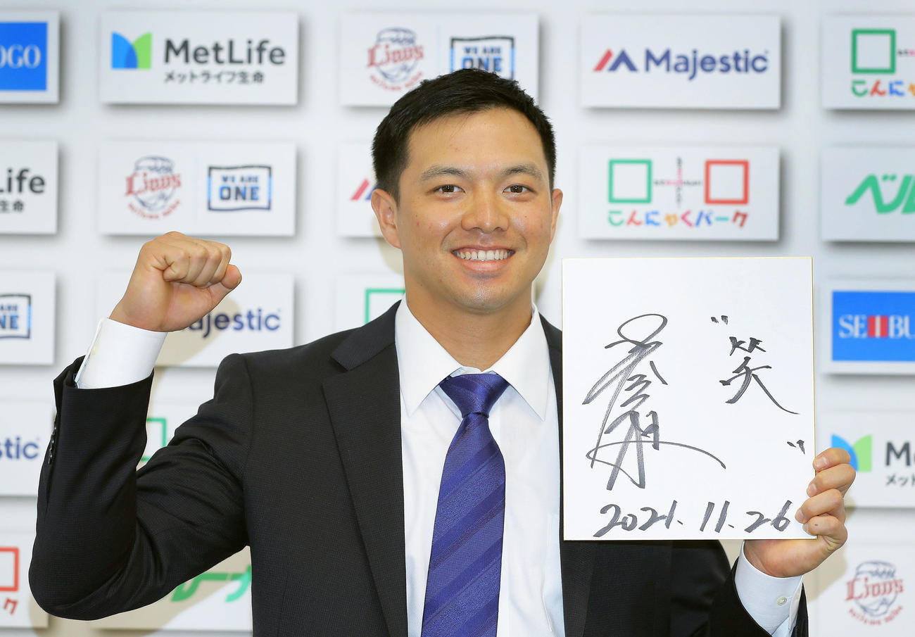 契約更改を終え、「笑」と記した色紙を掲げる西武呉（代表撮影）