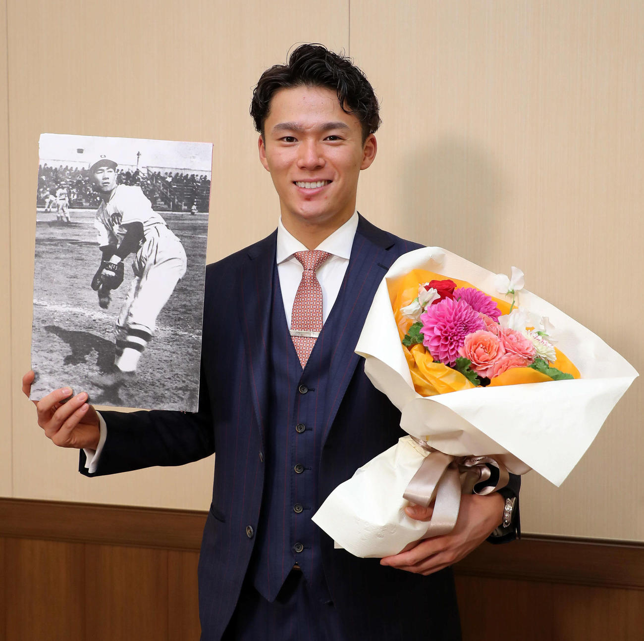 22日、沢村賞を受賞したオリックス山本は、沢村栄治投手の写真と花束を手に笑顔を見せる