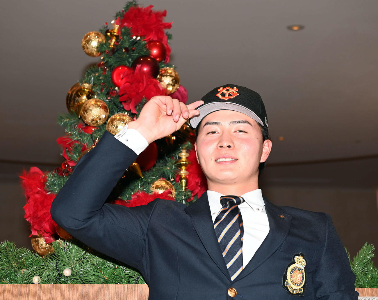 クリスマスツリーを背に「決め顔」を見せる巨人ドラフト5位の岡田（撮影・たえ見朱実）