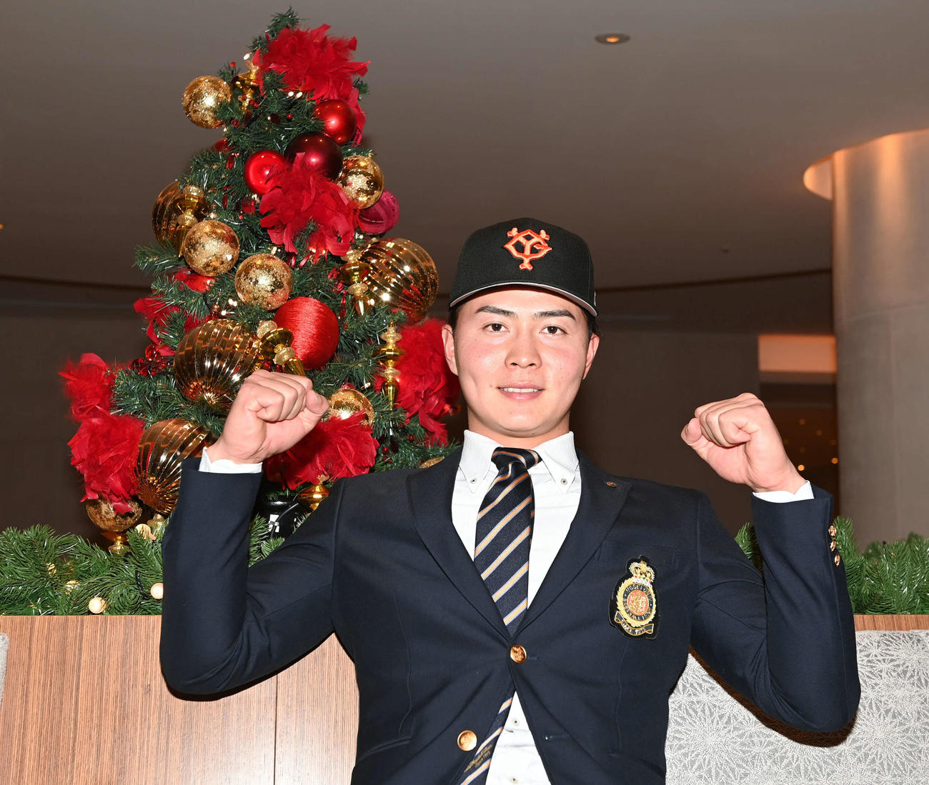 クリスマスツリーを背にガッツポーズを決める巨人ドラフト5位の岡田（撮影・たえ見朱実）