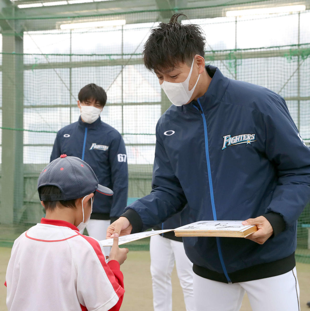 野球教室を終え子供たちにサインが書かれた色紙をプレゼントする日本ハム杉浦（撮影・佐藤翔太）