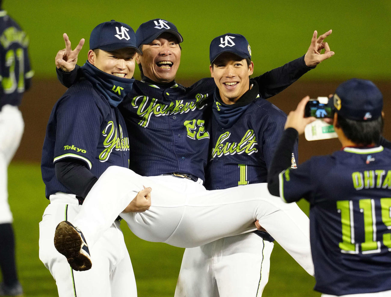 村上（左）と山田に持ち上げられピースサインのヤクルト高津監督（撮影・江口和貴）