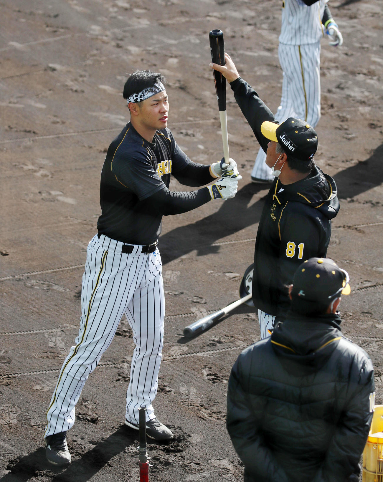 藤井コーチ（右）にアドバイスを受けながらティー打撃を行う佐藤輝（撮影・加藤哉）
