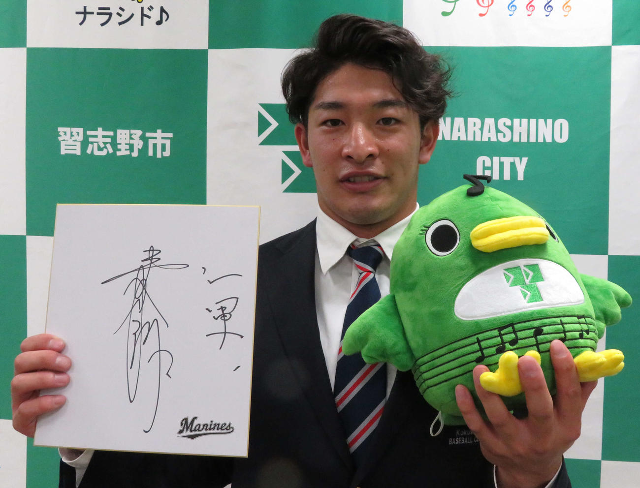 音符が描かれた習志野市ご当地キャラ「ナラシド」を持つロッテのドラフト2位池田（撮影・金子真仁）