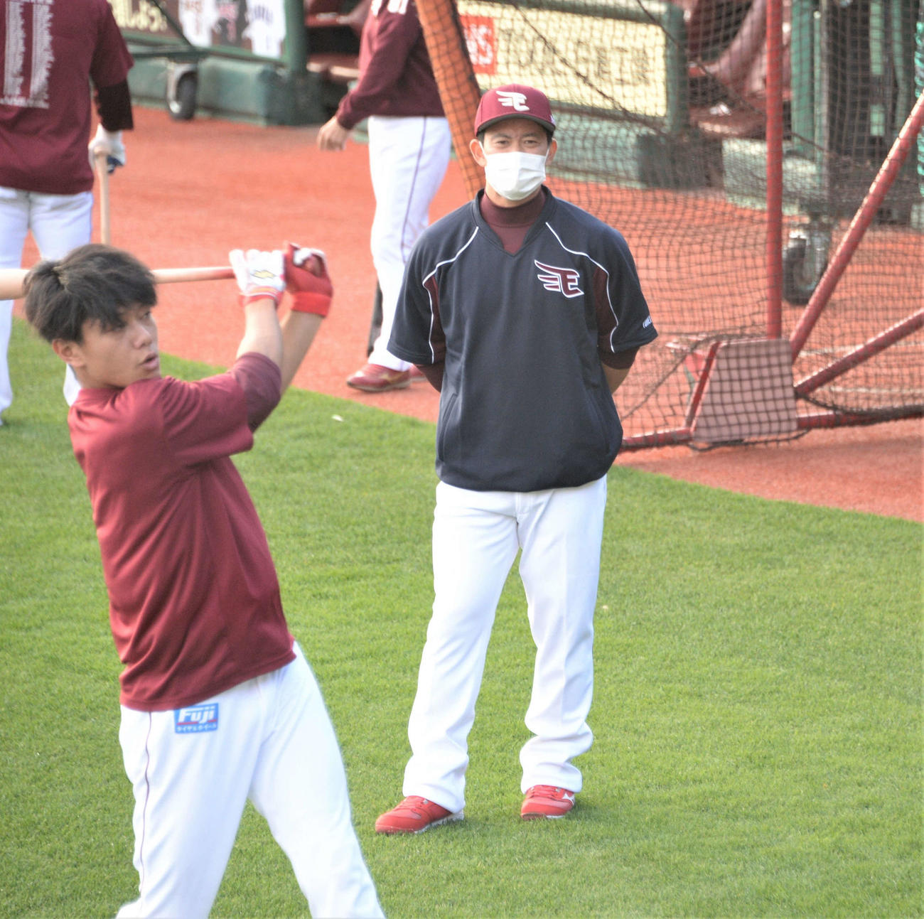 秋季練習で選手を見守る雄平コーチ。左は田中和

