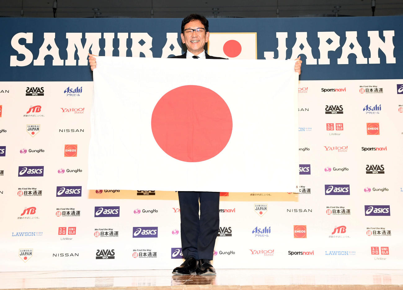 日の丸を手に笑顔を見せる侍ジャパン栗山新監督（撮影・たえ見朱実）