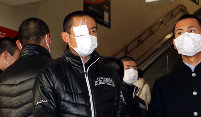 18年センバツで右目下を負傷した翌日、伊丹空港から北海道に戻る駒大苫小牧・道原（左）（撮影・永野高輔）