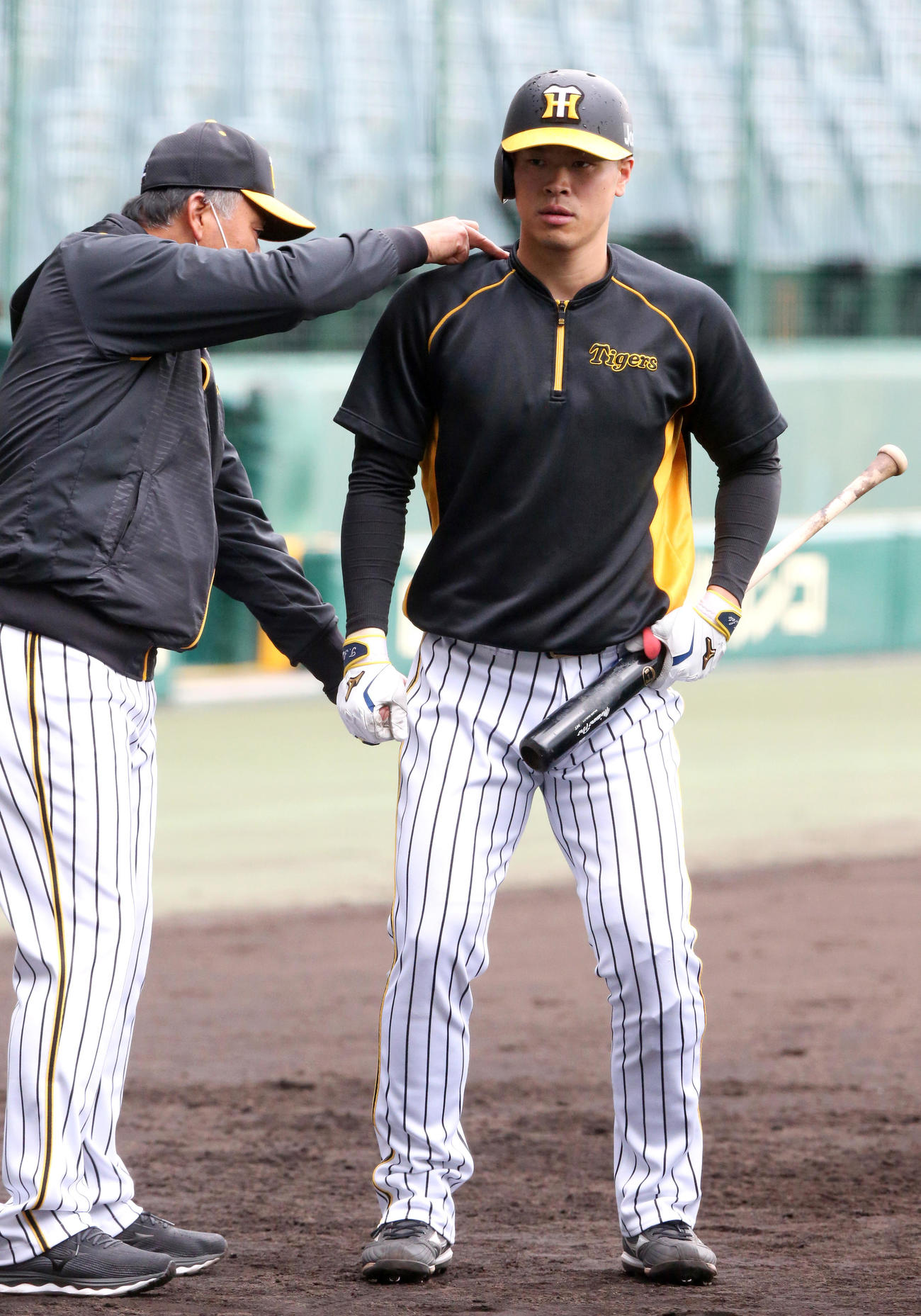 11月、藤井康コーチ（左）から指導を受ける佐藤輝（撮影・上山淳一）