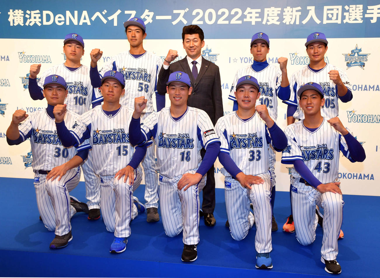 DeNA新入団選手発表会で三浦監督（後列中央）とガッツポーズで写真に納まる選手たち。前列左から三浦、徳山、小園、粟飯原、深沢、後列左から東出、梶原、1人おいて村川、大橋（代表撮影）