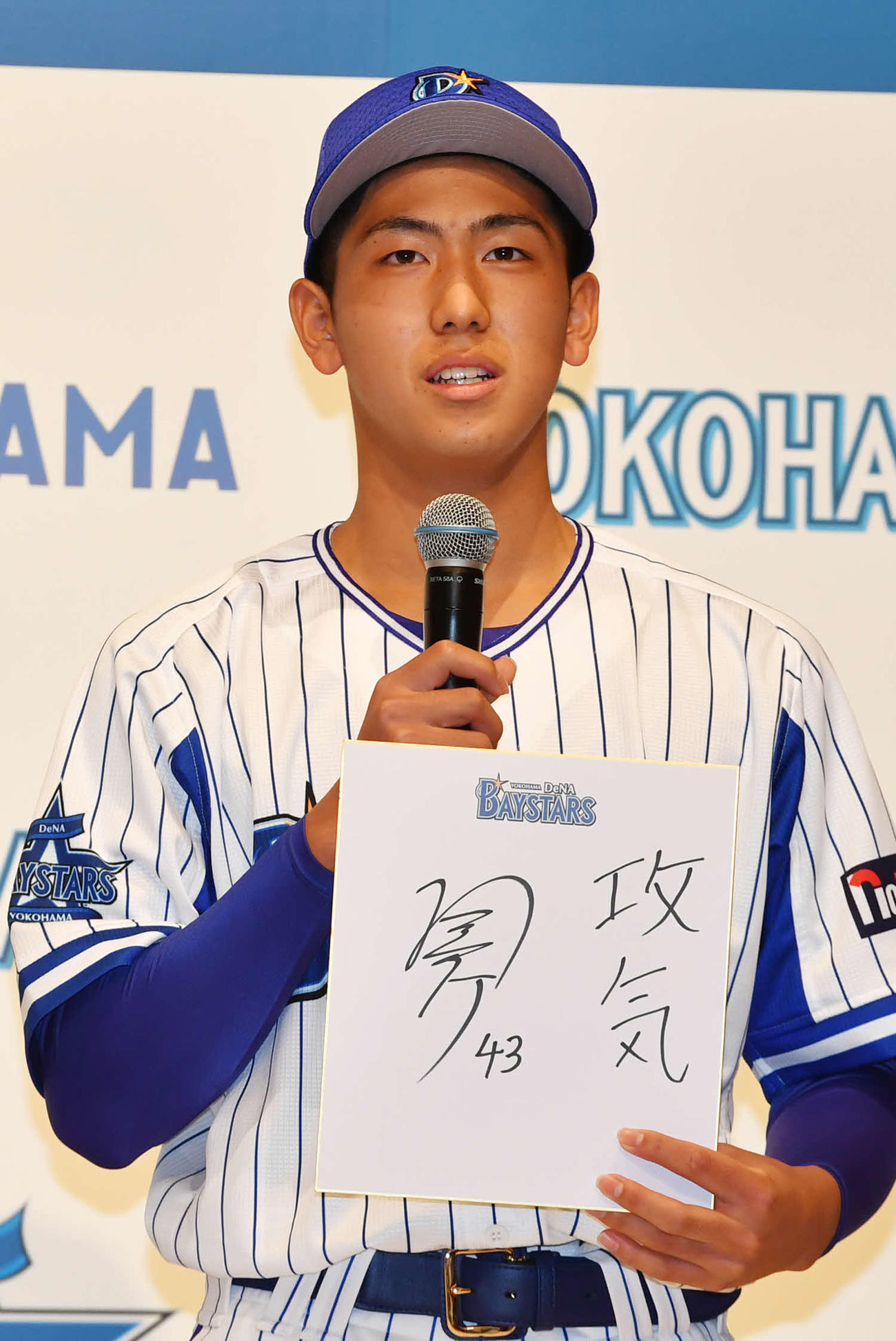 DeNA新入団選手発表会で色紙を手に抱負を語るドラフト5位の深沢（代表撮影）