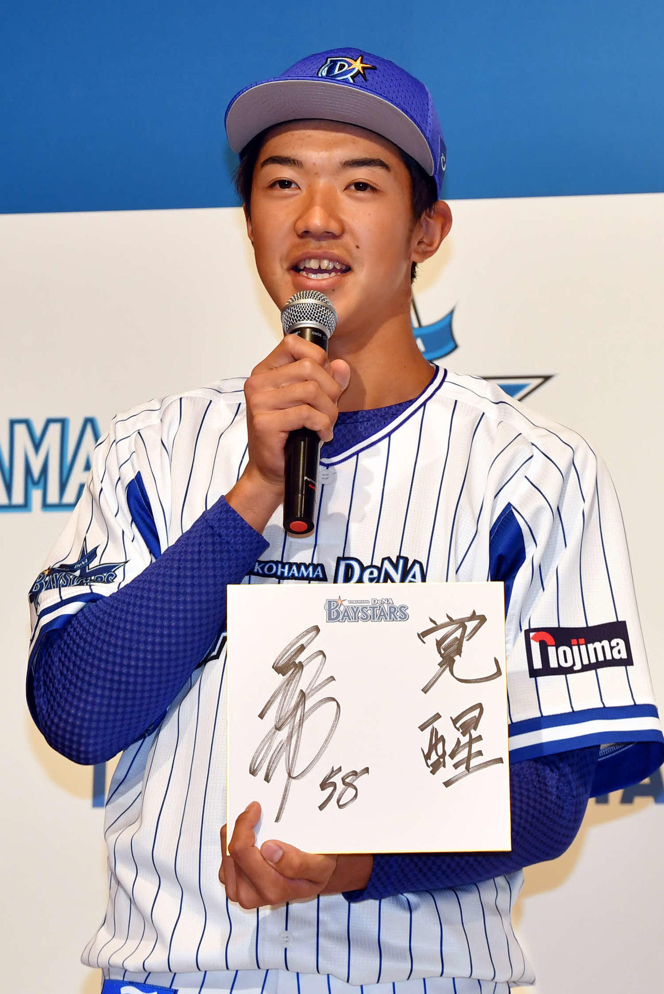 DeNA新入団選手発表会で色紙を手に抱負を語るドラフト6位の梶原（代表撮影）
