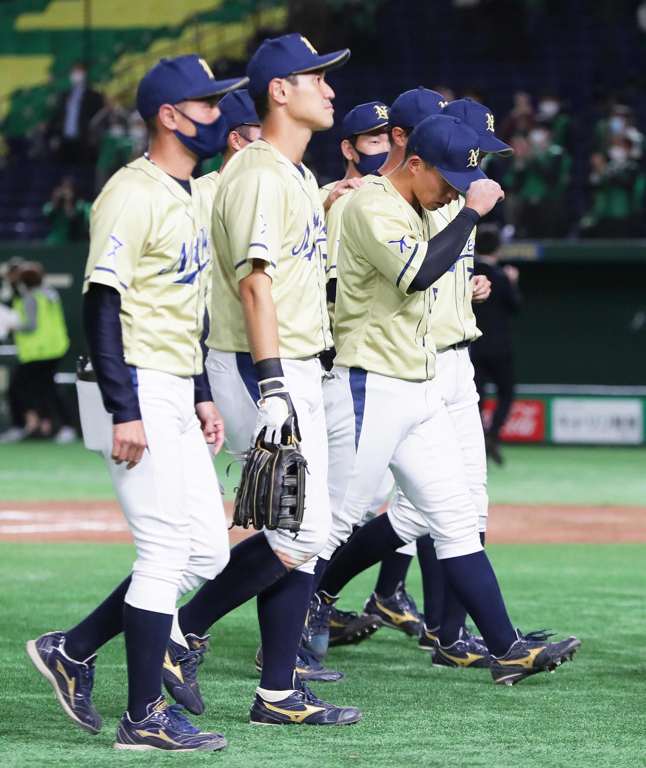 NTT西日本対JR東日本東北　サヨナラ負けを喫しがっくりと引き揚げるNTT西日本・野村（右）ら（撮影・足立雅史）